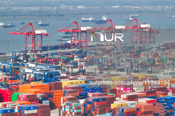 Cargo ships load and unload at berths, and trucks shuttle in the yard at Longtan Port area of Nanjing Port in Nanjing, Jiangsu province, Chi...