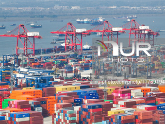 Cargo ships load and unload at berths, and trucks shuttle in the yard at Longtan Port area of Nanjing Port in Nanjing, Jiangsu province, Chi...