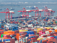 Cargo ships load and unload at berths, and trucks shuttle in the yard at Longtan Port area of Nanjing Port in Nanjing, Jiangsu province, Chi...