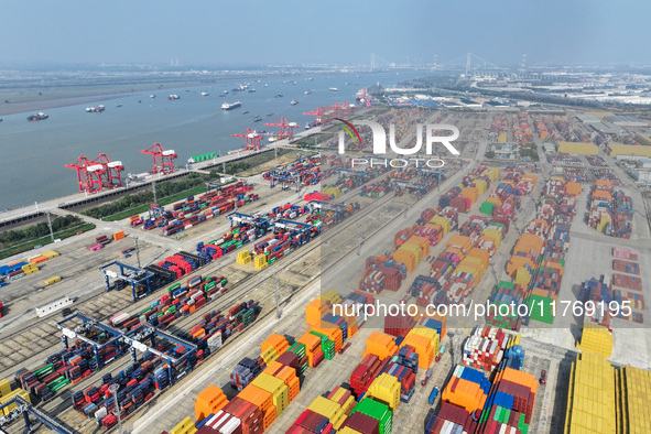 Cargo ships load and unload at berths, and trucks shuttle in the yard at Longtan Port area of Nanjing Port in Nanjing, Jiangsu province, Chi...