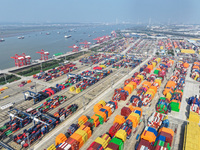 Cargo ships load and unload at berths, and trucks shuttle in the yard at Longtan Port area of Nanjing Port in Nanjing, Jiangsu province, Chi...