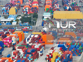 Cargo ships load and unload at berths, and trucks shuttle in the yard at Longtan Port area of Nanjing Port in Nanjing, Jiangsu province, Chi...