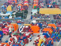 Cargo ships load and unload at berths, and trucks shuttle in the yard at Longtan Port area of Nanjing Port in Nanjing, Jiangsu province, Chi...