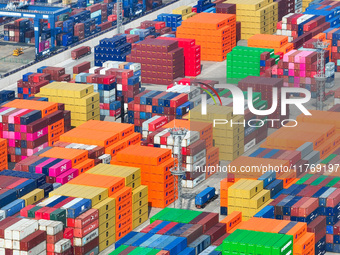 Cargo ships load and unload at berths, and trucks shuttle in the yard at Longtan Port area of Nanjing Port in Nanjing, Jiangsu province, Chi...