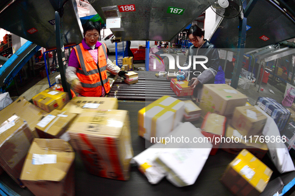 Staff work on an assembly line at the sorting center of Yancheng Yidatong Logistics Co LTD in Dafeng district of Yancheng City, East China's...