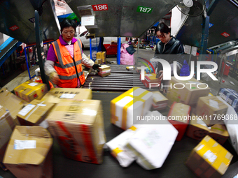 Staff work on an assembly line at the sorting center of Yancheng Yidatong Logistics Co LTD in Dafeng district of Yancheng City, East China's...