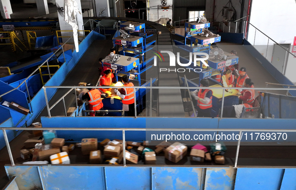 Staff work on an assembly line at the sorting center of Yancheng Yidatong Logistics Co LTD in Dafeng district of Yancheng City, East China's...