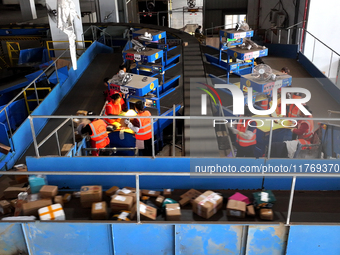 Staff work on an assembly line at the sorting center of Yancheng Yidatong Logistics Co LTD in Dafeng district of Yancheng City, East China's...