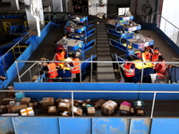 Staff work on an assembly line at the sorting center of Yancheng Yidatong Logistics Co LTD in Dafeng district of Yancheng City, East China's...