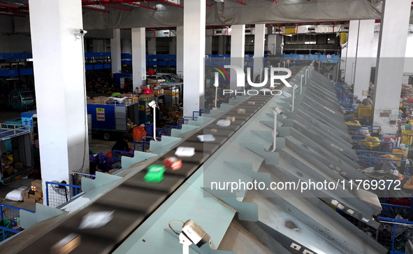 Staff work on an assembly line at the sorting center of Yancheng Yidatong Logistics Co LTD in Dafeng district of Yancheng City, East China's...