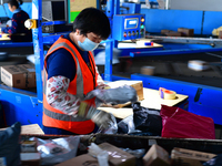 Staff work on an assembly line at the sorting center of Yancheng Yidatong Logistics Co LTD in Dafeng district of Yancheng City, East China's...