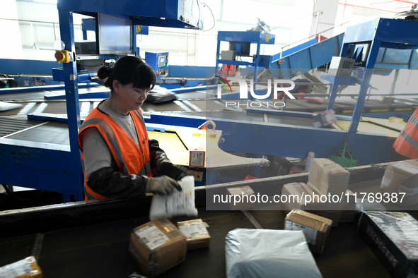 Staff work on an assembly line at the sorting center of Yancheng Yidatong Logistics Co LTD in Dafeng district of Yancheng City, East China's...