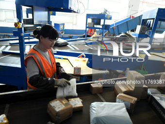 Staff work on an assembly line at the sorting center of Yancheng Yidatong Logistics Co LTD in Dafeng district of Yancheng City, East China's...