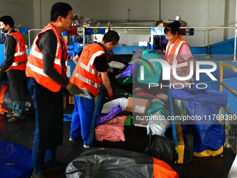 Staff work on an assembly line at the sorting center of Yancheng Yidatong Logistics Co LTD in Dafeng district of Yancheng City, East China's...