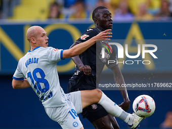 Jon Guridi of Deportivo Alaves competes for the ball with Gueye of Villarreal CF during the LaLiga EA Sports match between Villarreal CF and...