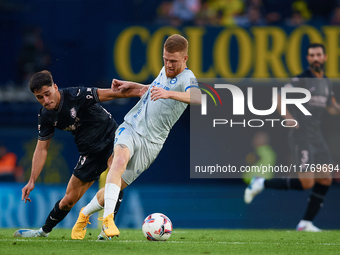 Carlos Vicente of Deportivo Alaves competes for the ball with Sergi Cardona of Villarreal CF during the LaLiga EA Sports match between Villa...