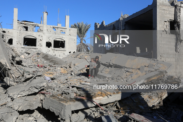 Palestinians gather on the rubble of a house destroyed in an Israeli strike at the Nuseirat refugee camp in the central Gaza Strip on Novemb...