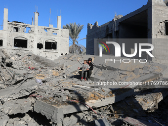 Palestinians gather on the rubble of a house destroyed in an Israeli strike at the Nuseirat refugee camp in the central Gaza Strip on Novemb...