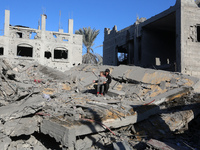 Palestinians gather on the rubble of a house destroyed in an Israeli strike at the Nuseirat refugee camp in the central Gaza Strip on Novemb...