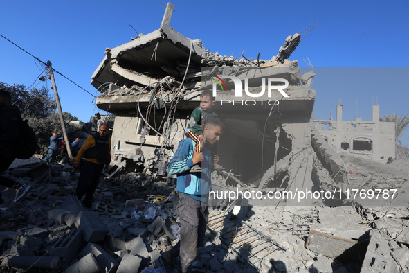 Palestinians gather on the rubble of a house destroyed in an Israeli strike at the Nuseirat refugee camp in the central Gaza Strip on Novemb...