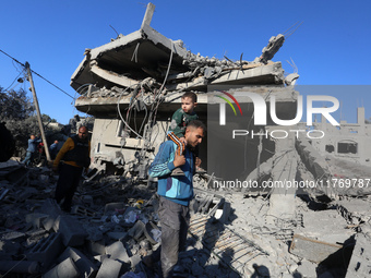 Palestinians gather on the rubble of a house destroyed in an Israeli strike at the Nuseirat refugee camp in the central Gaza Strip on Novemb...