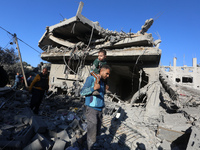 Palestinians gather on the rubble of a house destroyed in an Israeli strike at the Nuseirat refugee camp in the central Gaza Strip on Novemb...