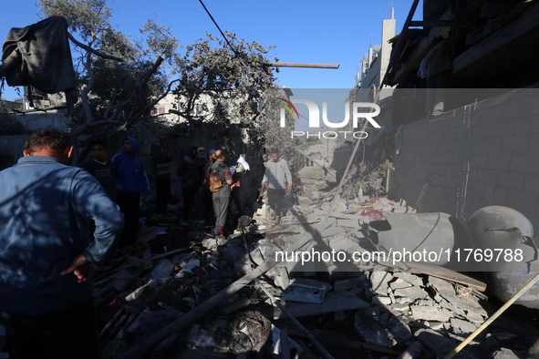 Palestinians gather on the rubble of a house destroyed in an Israeli strike at the Nuseirat refugee camp in the central Gaza Strip on Novemb...