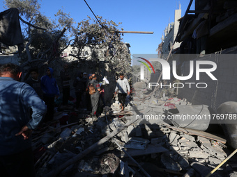 Palestinians gather on the rubble of a house destroyed in an Israeli strike at the Nuseirat refugee camp in the central Gaza Strip on Novemb...