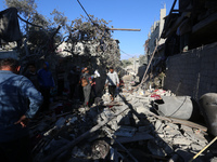 Palestinians gather on the rubble of a house destroyed in an Israeli strike at the Nuseirat refugee camp in the central Gaza Strip on Novemb...