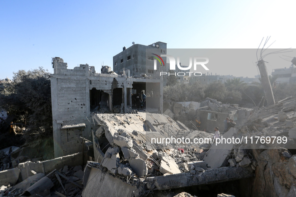 Palestinians gather on the rubble of a house destroyed in an Israeli strike at the Nuseirat refugee camp in the central Gaza Strip on Novemb...