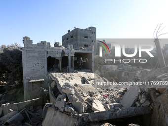 Palestinians gather on the rubble of a house destroyed in an Israeli strike at the Nuseirat refugee camp in the central Gaza Strip on Novemb...