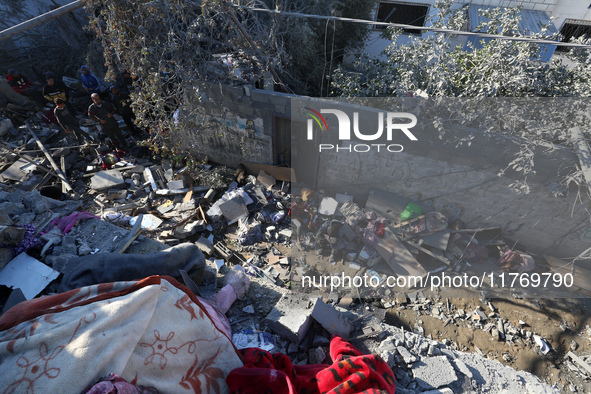 Palestinians gather on the rubble of a house destroyed in an Israeli strike at the Nuseirat refugee camp in the central Gaza Strip on Novemb...