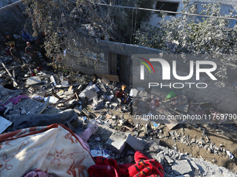 Palestinians gather on the rubble of a house destroyed in an Israeli strike at the Nuseirat refugee camp in the central Gaza Strip on Novemb...