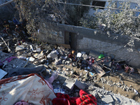 Palestinians gather on the rubble of a house destroyed in an Israeli strike at the Nuseirat refugee camp in the central Gaza Strip on Novemb...