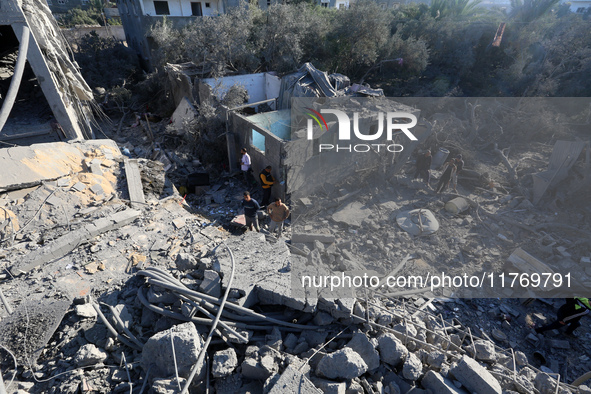 Palestinians gather on the rubble of a house destroyed in an Israeli strike at the Nuseirat refugee camp in the central Gaza Strip on Novemb...