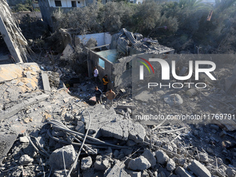 Palestinians gather on the rubble of a house destroyed in an Israeli strike at the Nuseirat refugee camp in the central Gaza Strip on Novemb...