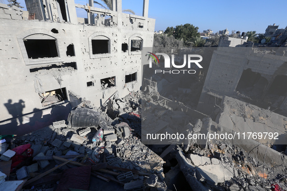 Palestinians gather on the rubble of a house destroyed in an Israeli strike at the Nuseirat refugee camp in the central Gaza Strip on Novemb...