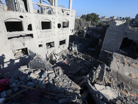 Palestinians gather on the rubble of a house destroyed in an Israeli strike at the Nuseirat refugee camp in the central Gaza Strip on Novemb...