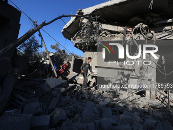 Palestinians gather on the rubble of a house destroyed in an Israeli strike at the Nuseirat refugee camp in the central Gaza Strip on Novemb...