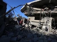 Palestinians gather on the rubble of a house destroyed in an Israeli strike at the Nuseirat refugee camp in the central Gaza Strip on Novemb...