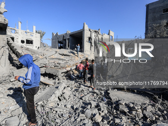 Palestinians gather on the rubble of a house destroyed in an Israeli strike at the Nuseirat refugee camp in the central Gaza Strip on Novemb...