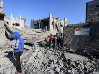 Palestinians gather on the rubble of a house destroyed in an Israeli strike at the Nuseirat refugee camp in the central Gaza Strip on Novemb...