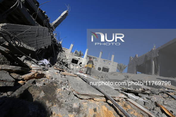 A Palestinian boy walks on the rubble of a house destroyed in an Israeli strike at the Nuseirat refugee camp in the central Gaza Strip on No...