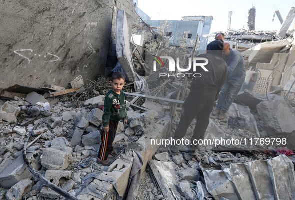 Palestinians gather on the rubble of a house destroyed in an Israeli strike at the Nuseirat refugee camp in the central Gaza Strip on Novemb...