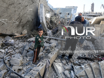 Palestinians gather on the rubble of a house destroyed in an Israeli strike at the Nuseirat refugee camp in the central Gaza Strip on Novemb...