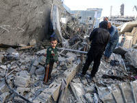 Palestinians gather on the rubble of a house destroyed in an Israeli strike at the Nuseirat refugee camp in the central Gaza Strip on Novemb...