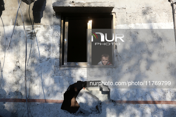 A boy looks at a house destroyed in an Israeli strike at the Nuseirat refugee camp in the central Gaza Strip on November 12, 2024, amid the...