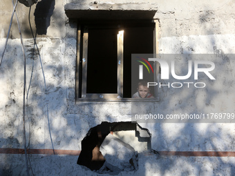 A boy looks at a house destroyed in an Israeli strike at the Nuseirat refugee camp in the central Gaza Strip on November 12, 2024, amid the...