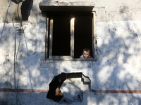 A boy looks at a house destroyed in an Israeli strike at the Nuseirat refugee camp in the central Gaza Strip on November 12, 2024, amid the...