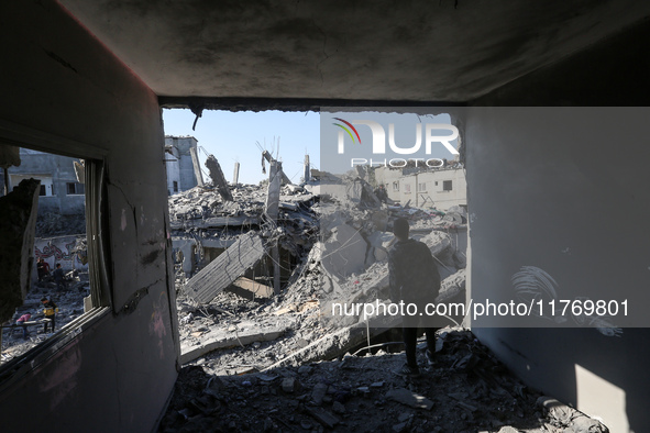 Palestinians gather on the rubble of a house destroyed in an Israeli strike at the Nuseirat refugee camp in the central Gaza Strip on Novemb...